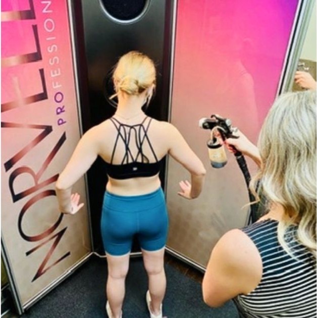 Sunsations technician applying a custom spray tan in Topeka, Kansas